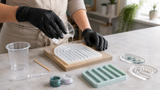 Maker carefully pouring clear resin into silicone moulds on a clean, level craft bench