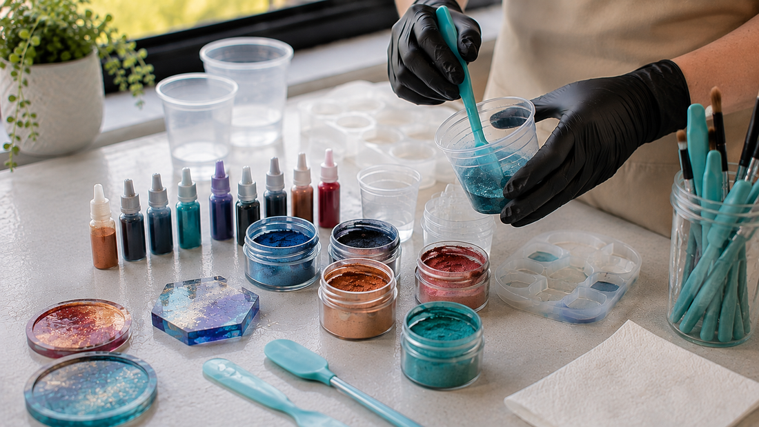 Resin colourants, mica powders and metallic pigments beside clear resin and mixing tools on a tidy craft workspace